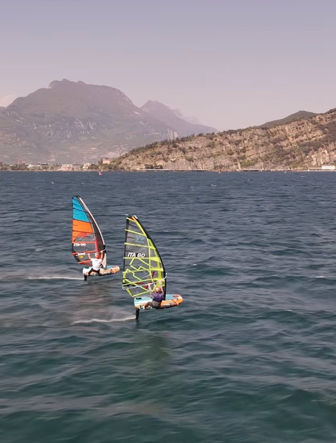 Two windsurf foilers racing on Lake Garda during the Austrian Cup 2025, ITA 60 leading